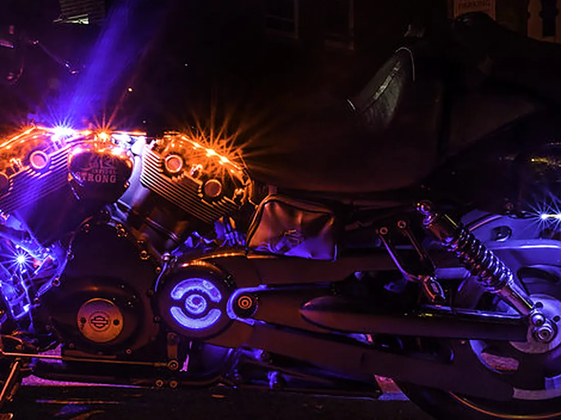 Detalle de moto custom con luces de neón violeta