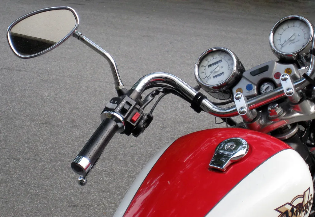 Tanque y espejo cromado de una moto roja